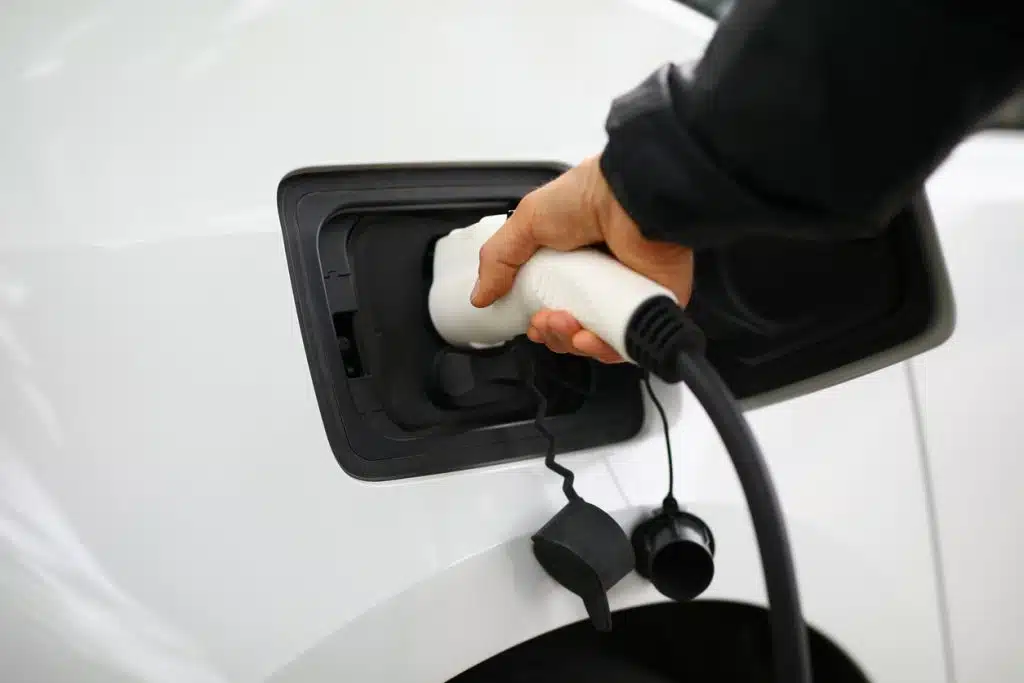Driver inserts electric charger into vehicle