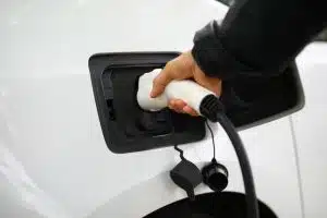 Driver inserts electric charger into vehicle